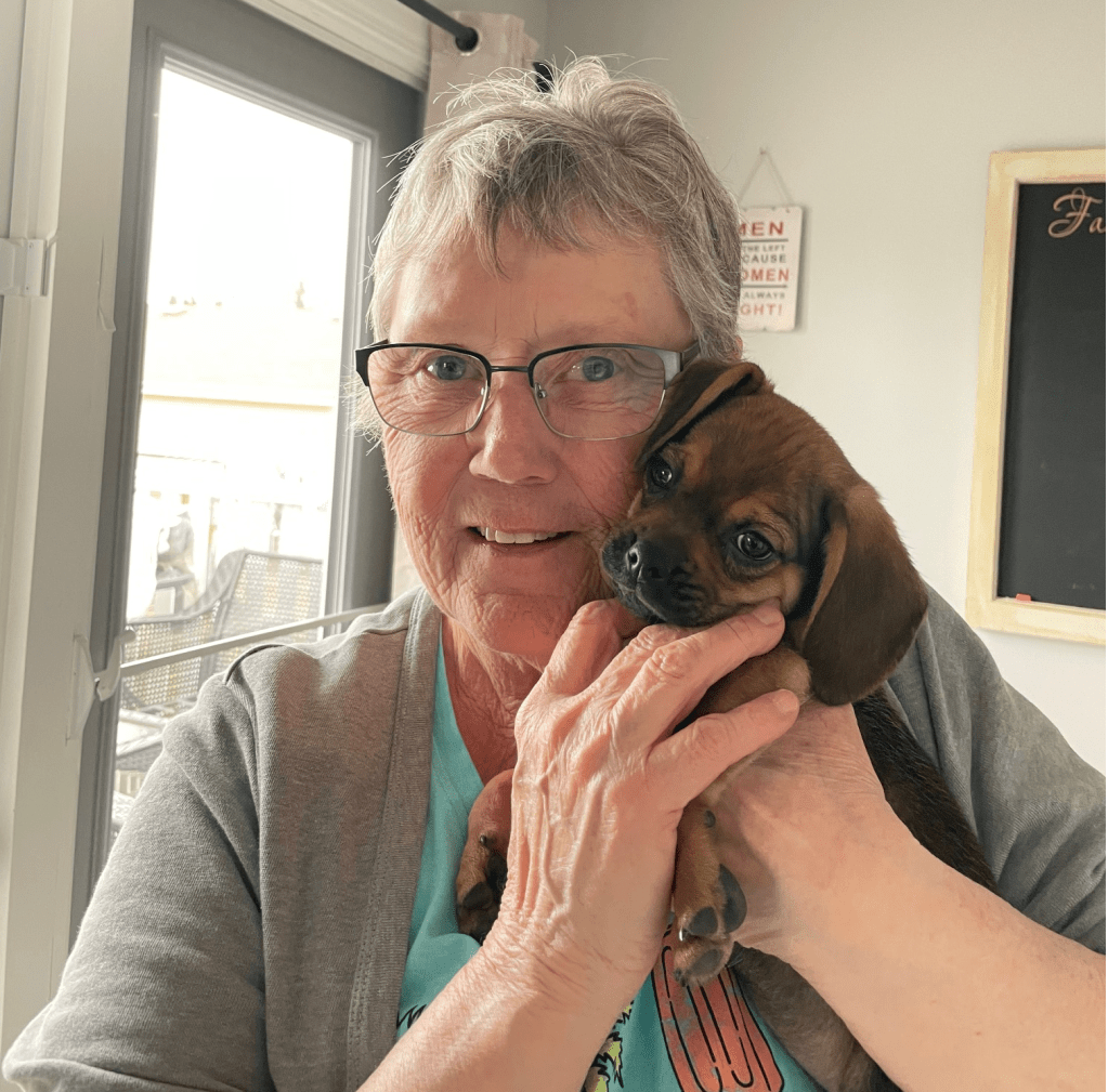 woman holding little puppy